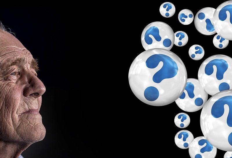 old man looking at bubbles filled with question marks