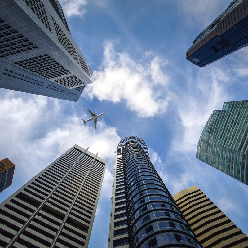 looking up at buildings and plane flying by