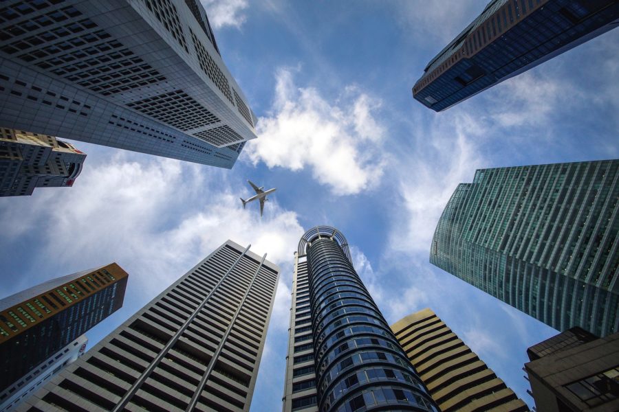 looking up at buildings and plane flying by