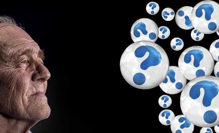 old man looking at bubbles filled with question marks